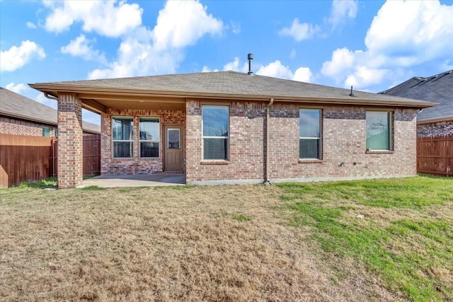 back of property with a patio and a yard