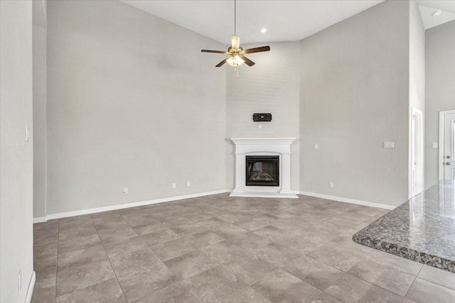 unfurnished living room featuring ceiling fan and high vaulted ceiling