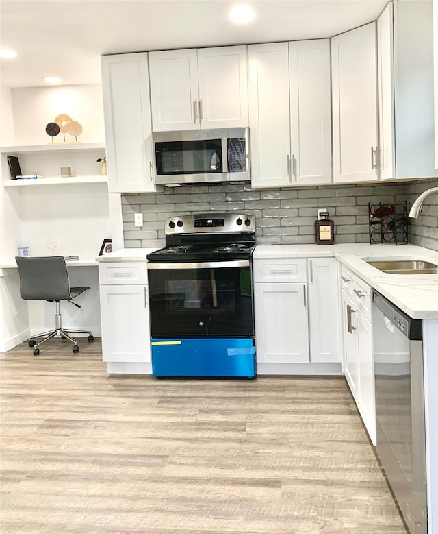 kitchen with sink, stainless steel appliances, light hardwood / wood-style floors, and white cabinets