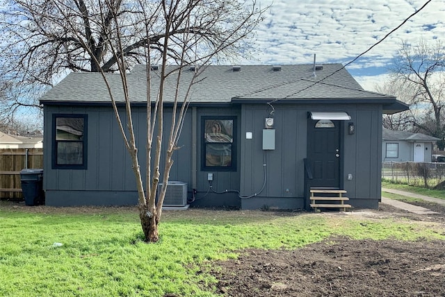 back of house featuring central AC and a lawn