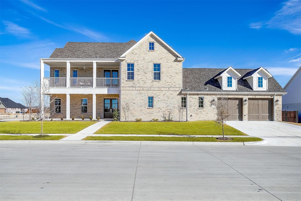 view of front of home with a front lawn, a garage, and a balcony