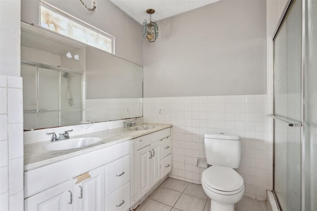 bathroom with walk in shower, vanity, tile patterned floors, and a textured ceiling