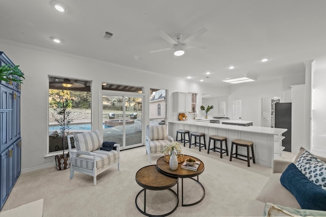 living room featuring light carpet, crown molding, and ceiling fan