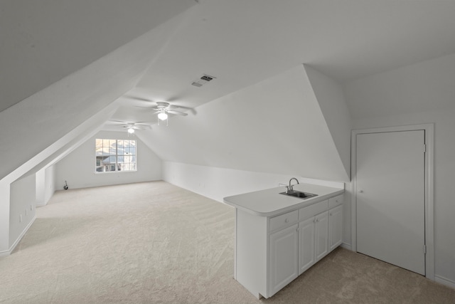 additional living space featuring vaulted ceiling, sink, light carpet, and ceiling fan