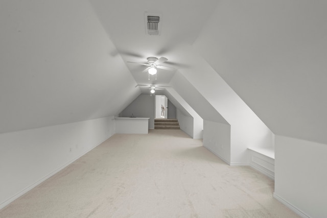 additional living space with vaulted ceiling, light carpet, and ceiling fan