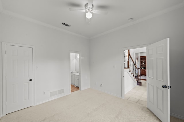 bedroom featuring ceiling fan, ensuite bath, ornamental molding, and light carpet