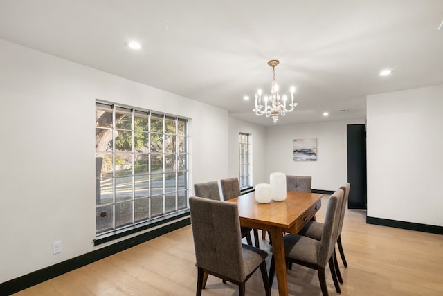 dining space with light wood-type flooring and an inviting chandelier