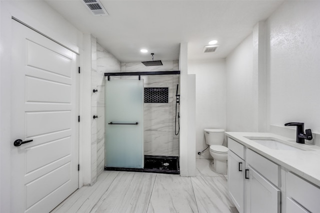 bathroom featuring a shower with shower door, toilet, and vanity