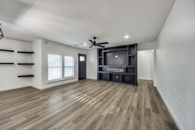 unfurnished living room with hardwood / wood-style flooring and ceiling fan