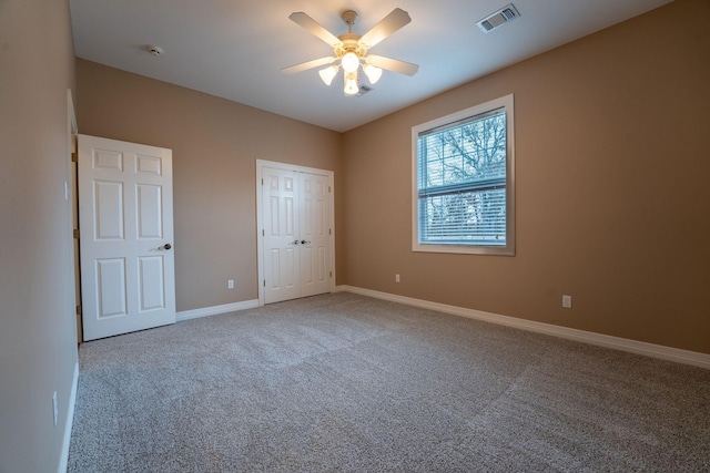 unfurnished bedroom featuring carpet floors, ceiling fan, and a closet