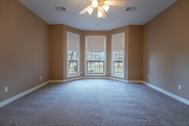 empty room with ceiling fan and carpet floors