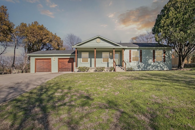 view of front of property featuring a lawn, covered porch, and a garage