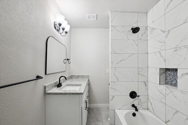 bathroom with tiled shower / bath combo and vanity