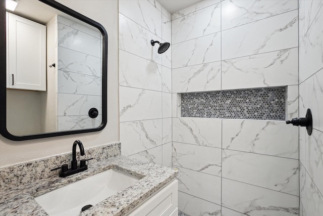 bathroom featuring a tile shower and vanity