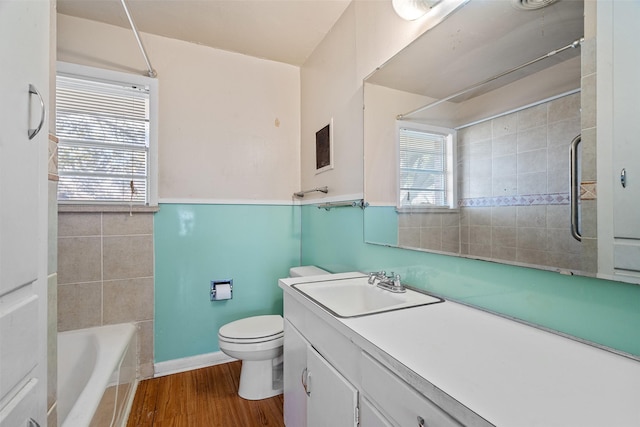 full bathroom featuring hardwood / wood-style floors, toilet, vanity, and a healthy amount of sunlight