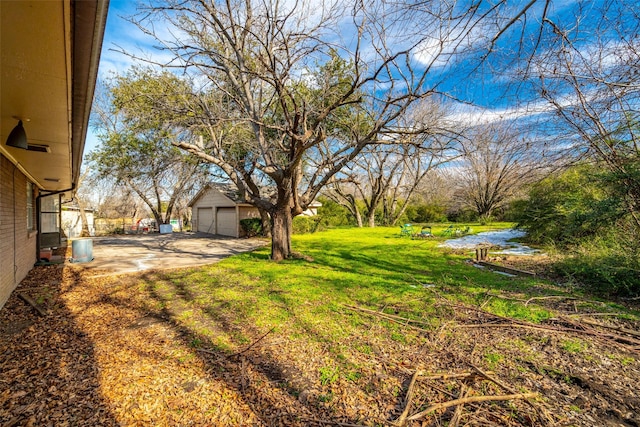 view of yard featuring a water view, an outdoor structure, and a garage