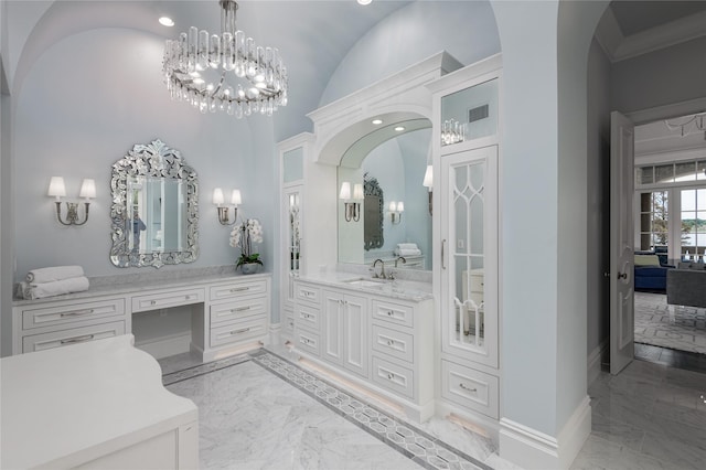 bathroom featuring a towering ceiling, vanity, and a chandelier