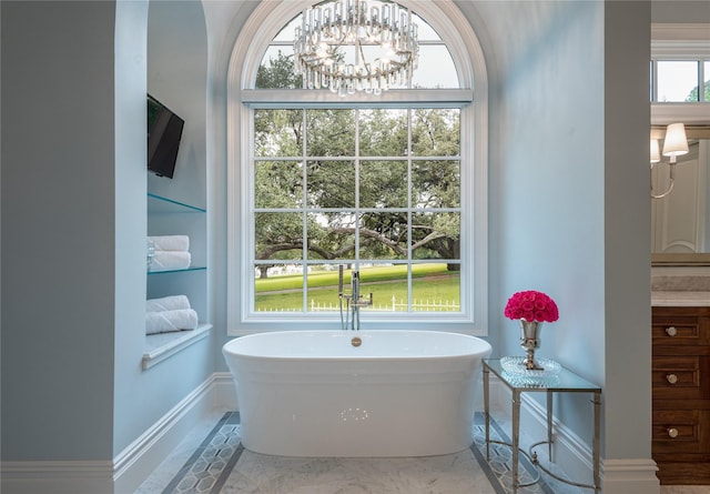 bathroom featuring an inviting chandelier, tile patterned floors, and a bathtub