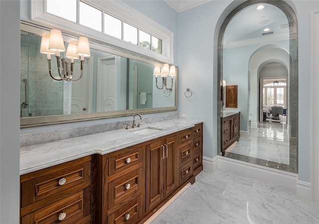 bathroom with a wealth of natural light, crown molding, a chandelier, and vanity