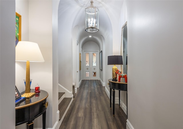 corridor featuring dark wood-type flooring and a chandelier