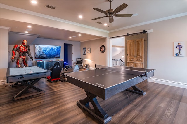 rec room featuring ceiling fan, a barn door, dark hardwood / wood-style floors, and crown molding