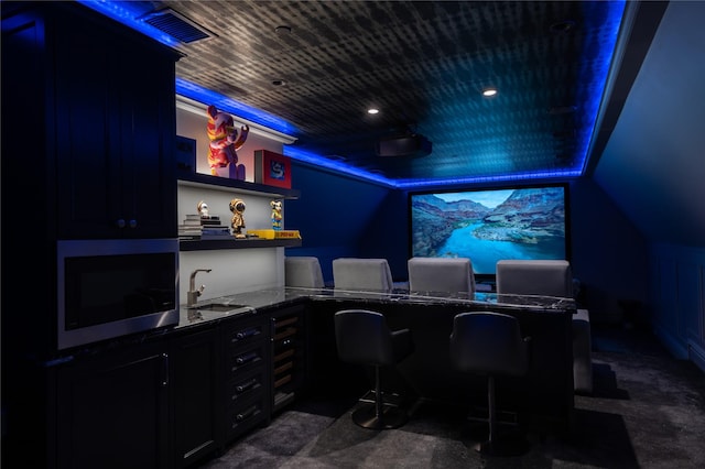 carpeted home office featuring sink and vaulted ceiling