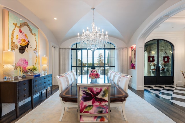 dining area featuring vaulted ceiling, dark wood-type flooring, french doors, and an inviting chandelier