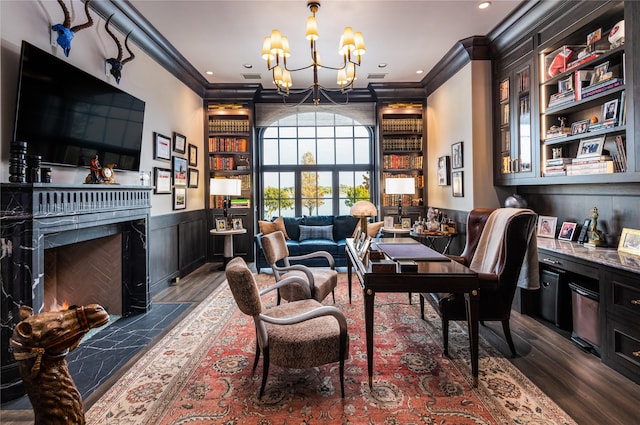 interior space featuring an inviting chandelier, dark hardwood / wood-style flooring, crown molding, and built in shelves