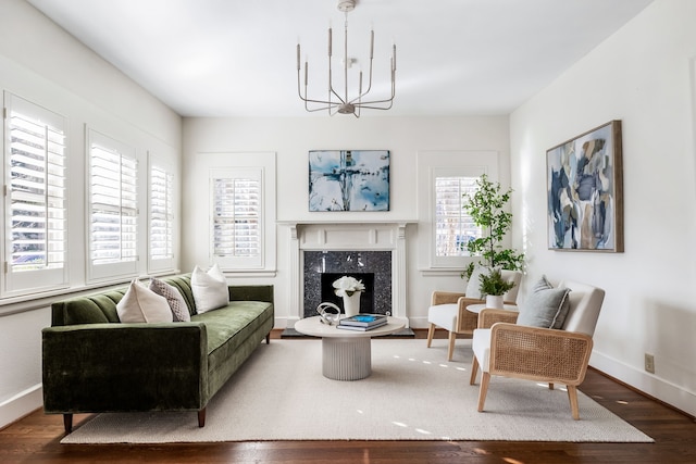 living room featuring a high end fireplace, a wealth of natural light, a chandelier, and hardwood / wood-style flooring