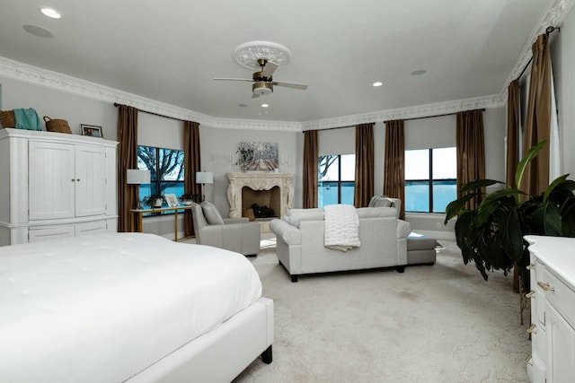 carpeted bedroom featuring ceiling fan, a high end fireplace, and ornamental molding