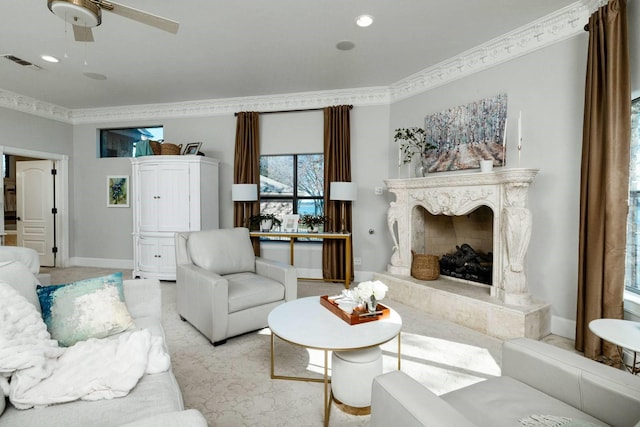 living room with ceiling fan, a high end fireplace, and crown molding