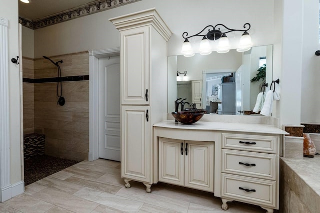 bathroom featuring tiled shower and vanity