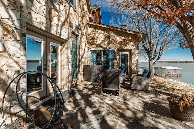 deck with french doors and a water view