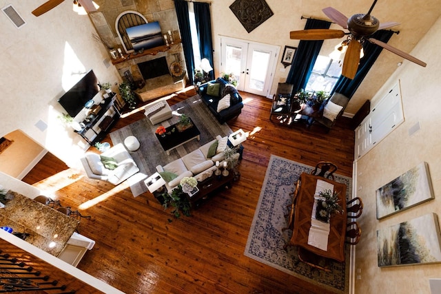 living room featuring a high ceiling, ceiling fan, dark hardwood / wood-style flooring, and french doors