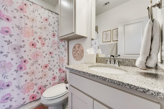 bathroom with toilet, vanity, and a shower with curtain