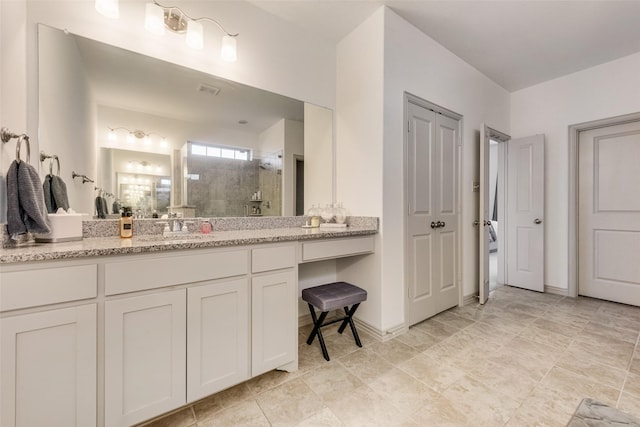 bathroom with vanity and tiled shower