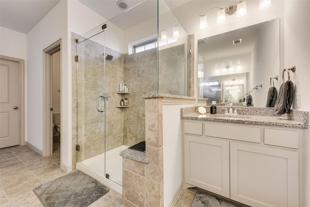 bathroom featuring an enclosed shower, vanity, and toilet