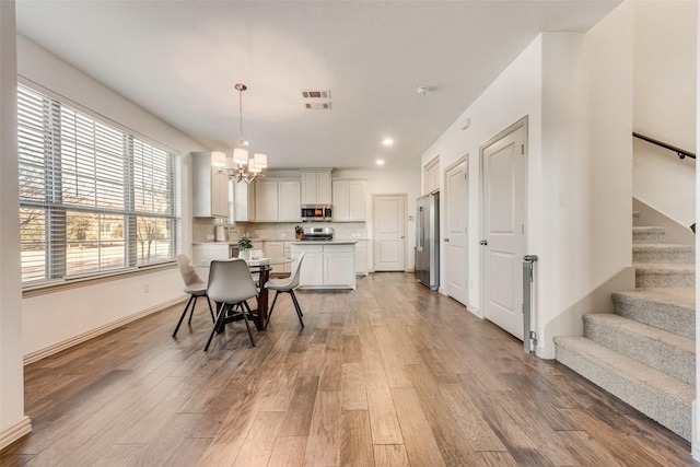 dining room with a chandelier and light hardwood / wood-style flooring