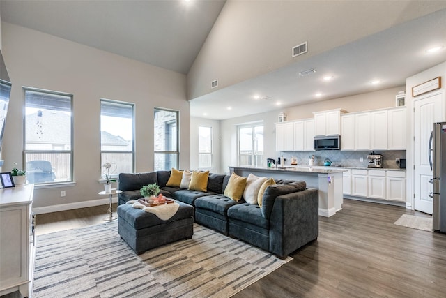 living room featuring light wood-type flooring and high vaulted ceiling