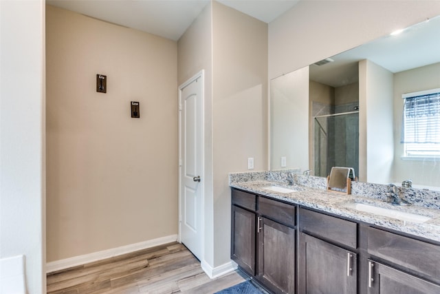 bathroom featuring a shower with shower door, vanity, and hardwood / wood-style flooring