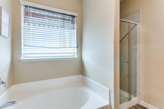 bathroom featuring a healthy amount of sunlight and independent shower and bath