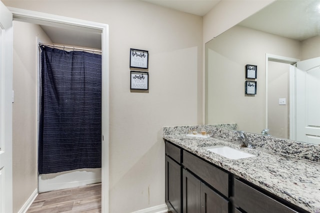 bathroom with wood-type flooring, vanity, and shower / tub combo with curtain