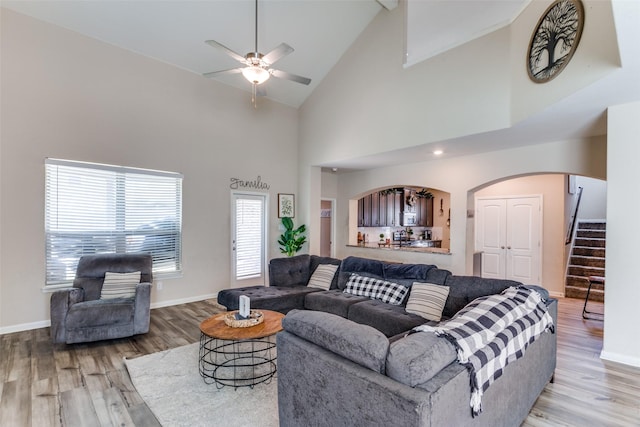 living room featuring high vaulted ceiling, ceiling fan, and light hardwood / wood-style floors