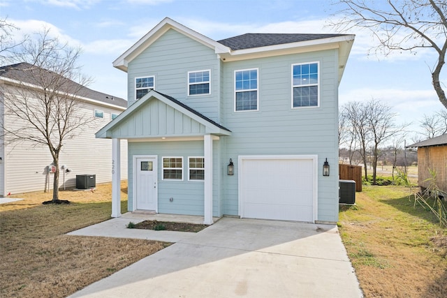 view of front of home with cooling unit, a garage, and a front lawn