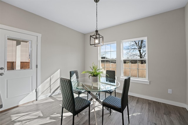 dining area with baseboards and wood finished floors