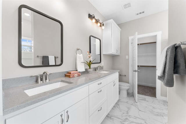 full bathroom with a walk in closet, marble finish floor, visible vents, and a sink