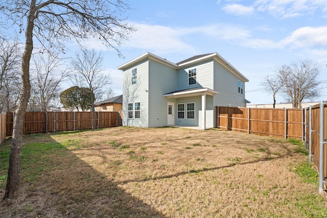 rear view of property with a yard and a fenced backyard