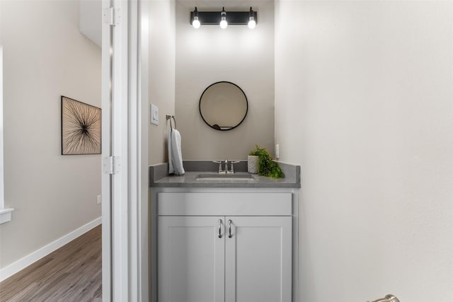 bathroom featuring vanity, baseboards, and wood finished floors