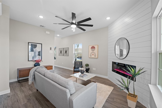 living area with dark wood-type flooring, a fireplace, recessed lighting, and baseboards