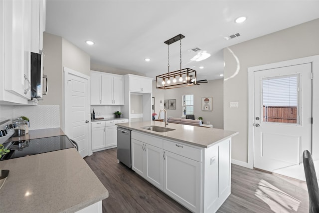 kitchen featuring visible vents, an island with sink, appliances with stainless steel finishes, white cabinetry, and a sink